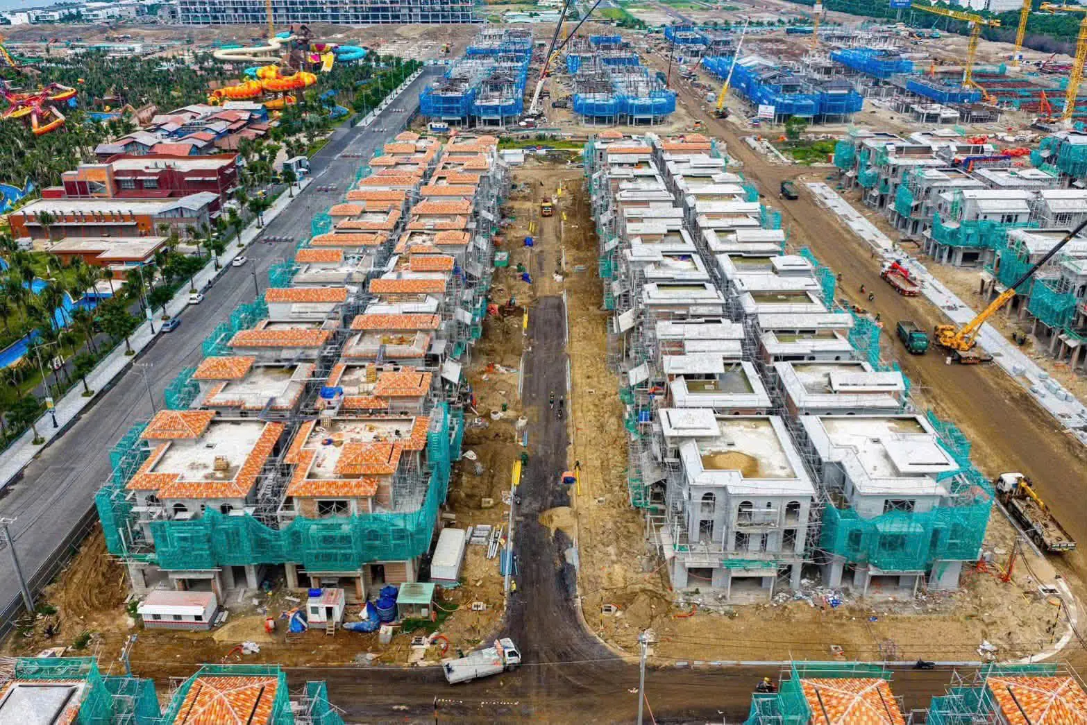 Ảnh chụp công trường khu thấp tầng Casa Blanca City tháng 07/2026, các dãy biệt thự đã xây xong tường, một số căn đã lợp mái ngói đỏ và hoàn thiện mặt ngoài, số còn lại vẫn quây giàn giáo